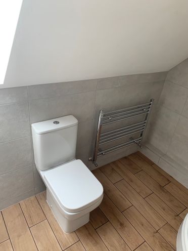 Bijou Rimless C/C Toilet; 500 x 800 Chrome Towel Warmer. Canvas Grey Tiles.